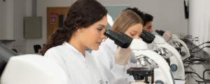 Estudantes em aula prática do curso de Biomedicina da Faculdade IPOG, utilizando equipamentos modernos de laboratório.