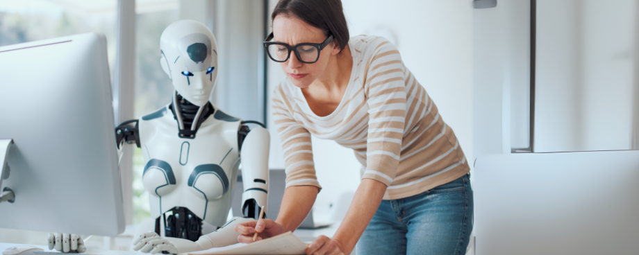 Mulher trabalhando em escritório ao lado de robô humanoide, representando a aplicação prática de agentes de IA e automação inteligente nos negócios.