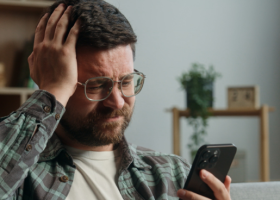 TCC para ludopatia - homem com celular na mão apostando em bets.